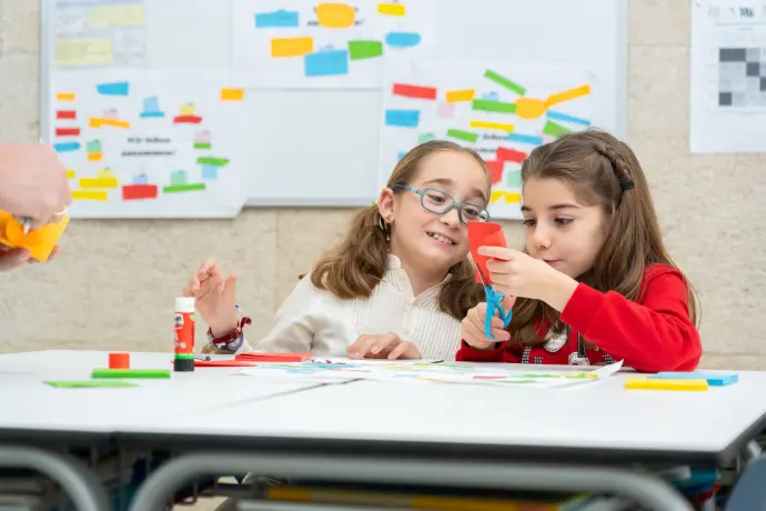 niñas clase pizarra recortando